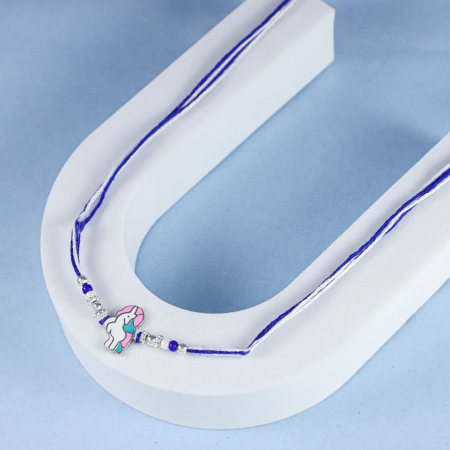 Pastel Unicorn  Silver Rakhi with Blue and White Thread