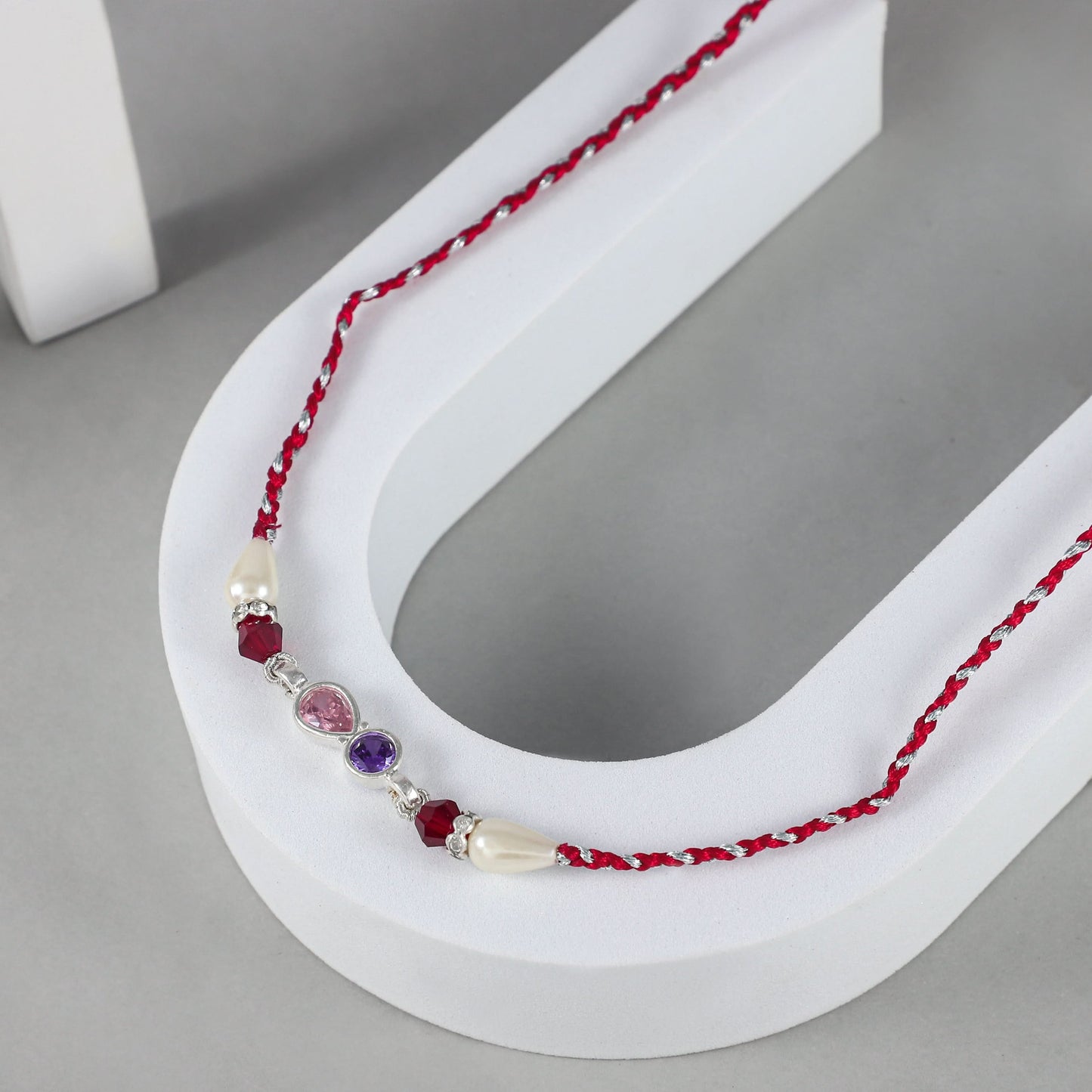 Elegant Silver Rakhi with Gemstone and Pearl Accents